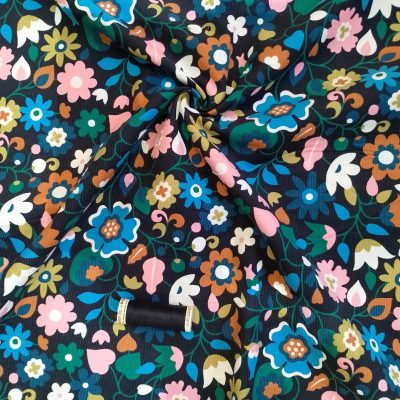 Vibrant floral print 21Wale Needlecord on a black background
